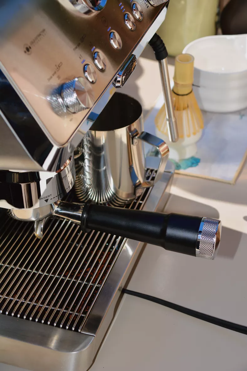 Cafetera profesional con utensilios de matcha en barra de café