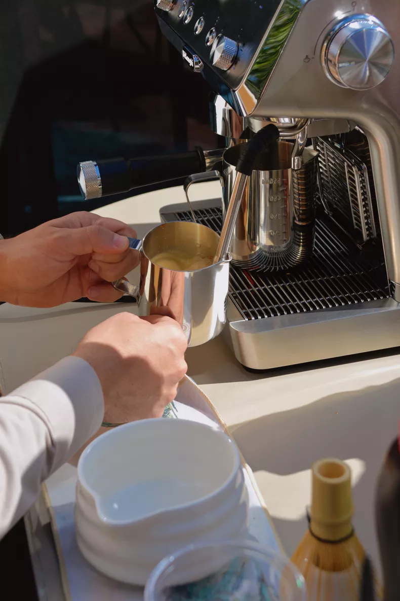 Barista texturizando leche en máquina de espresso profesional